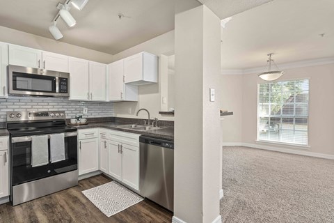 a kitchen with stainless steel appliances and white cabinets