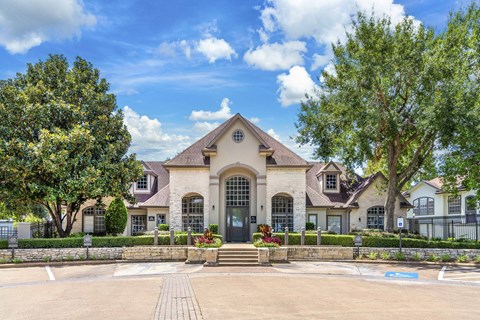 the front of a house with trees and a driveway