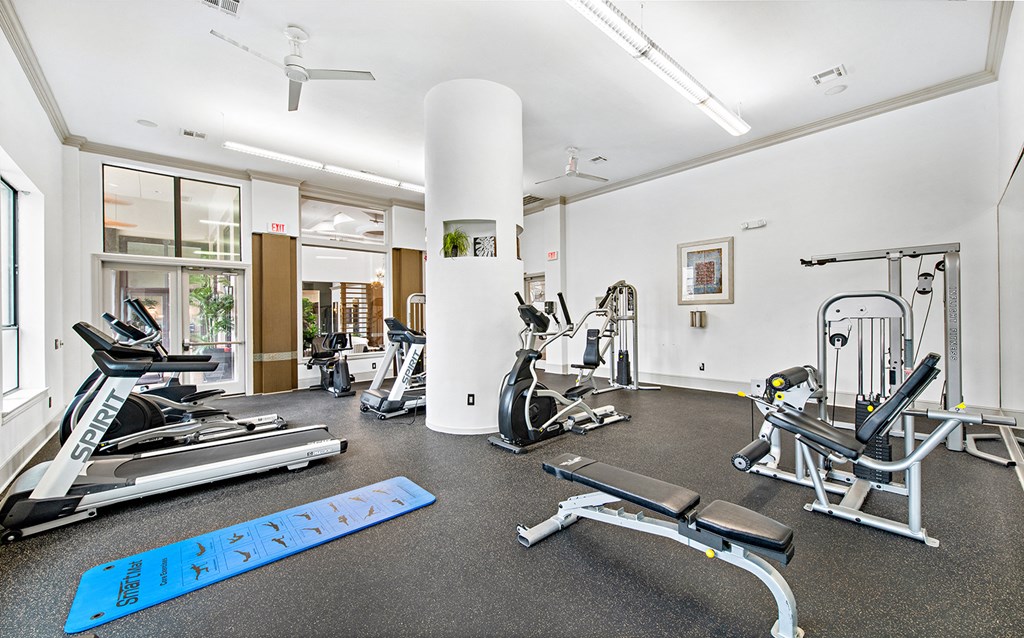a gym with treadmills and other exercise equipment on the floor