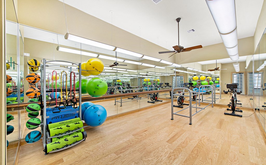 a large fitness room with weights and other exercise equipment