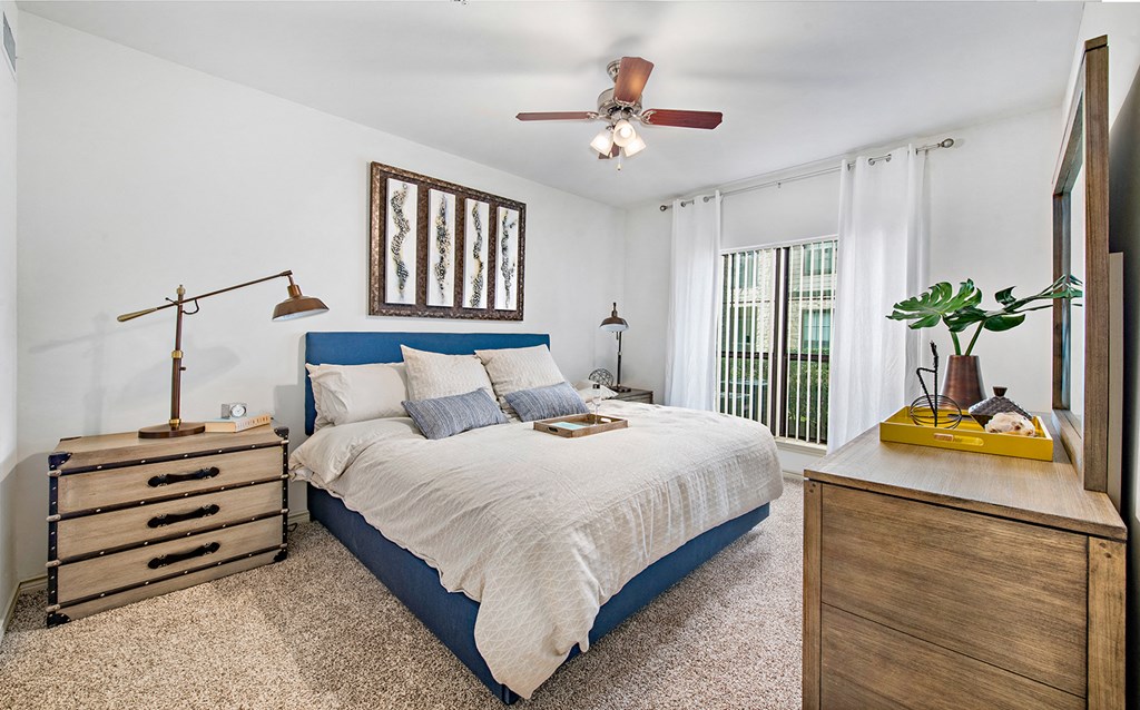 a bedroom with a bed and a ceiling fan