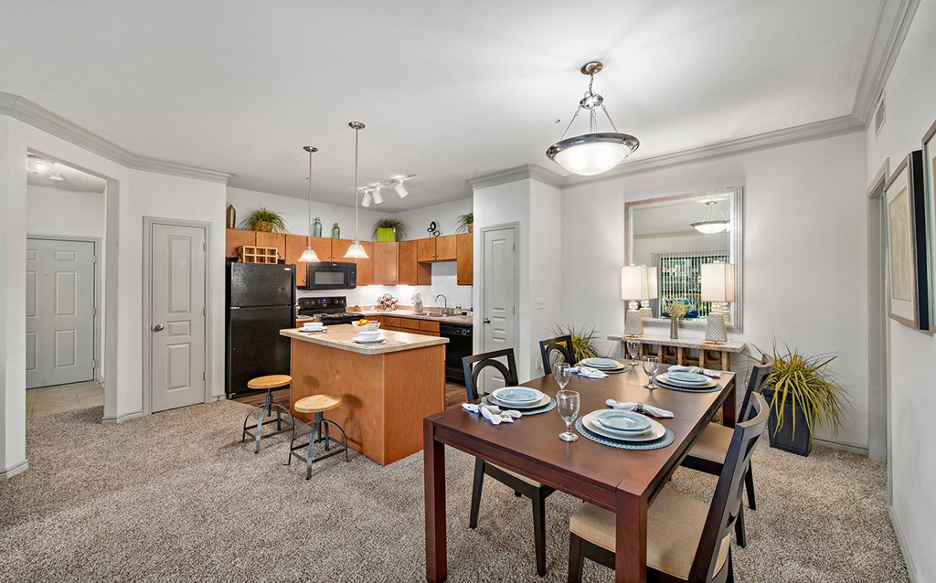 an open kitchen and dining room with a wooden table and chairs