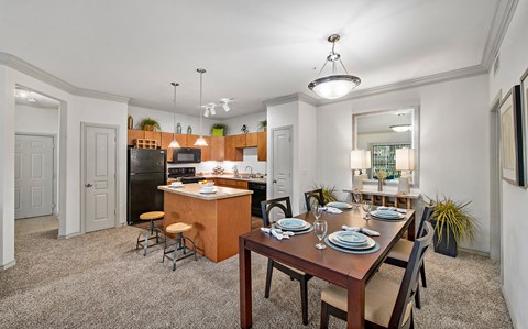 an open kitchen and dining room with a wooden table and chairs