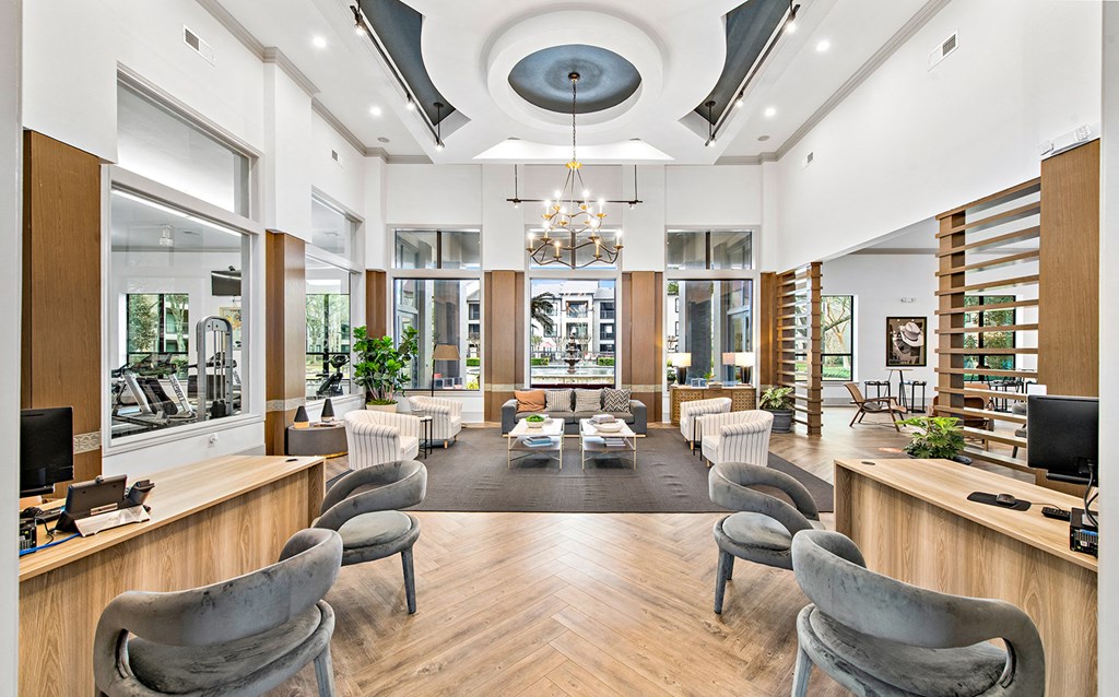 the lobby of a library with chairs and tables and a large window