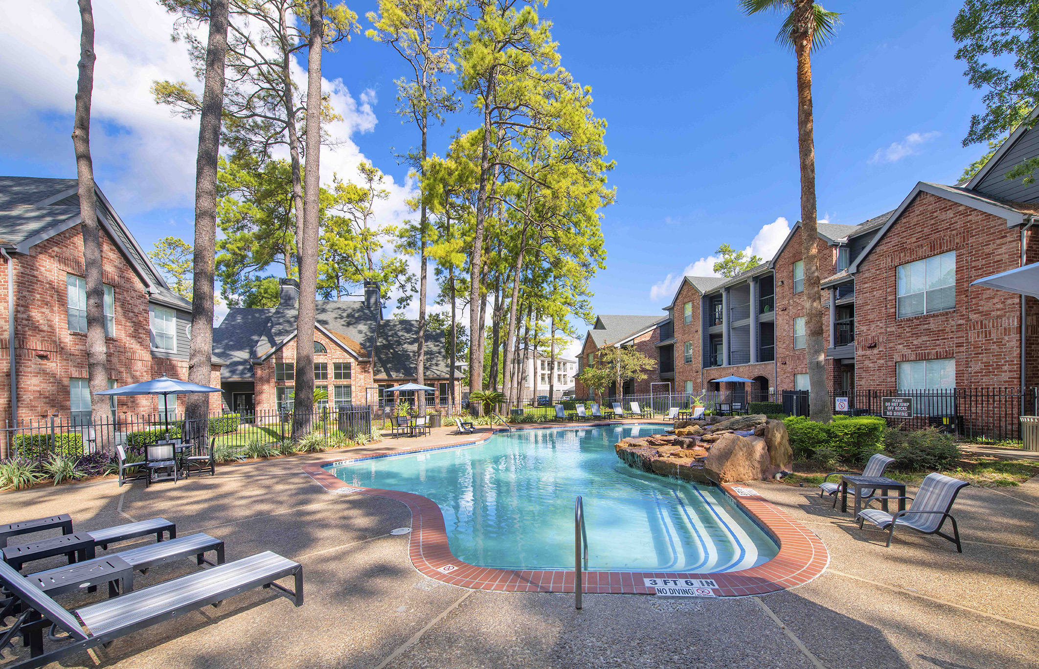 a swimming pool with buildings and trees in the background