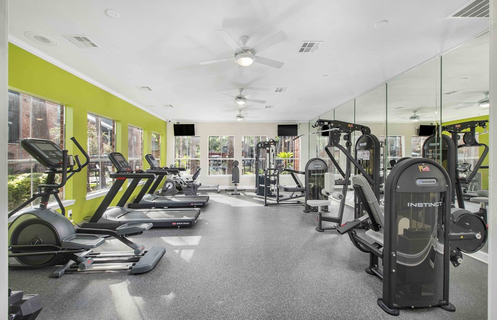 A gym with treadmills, elliptical machines, and other exercise equipment.
