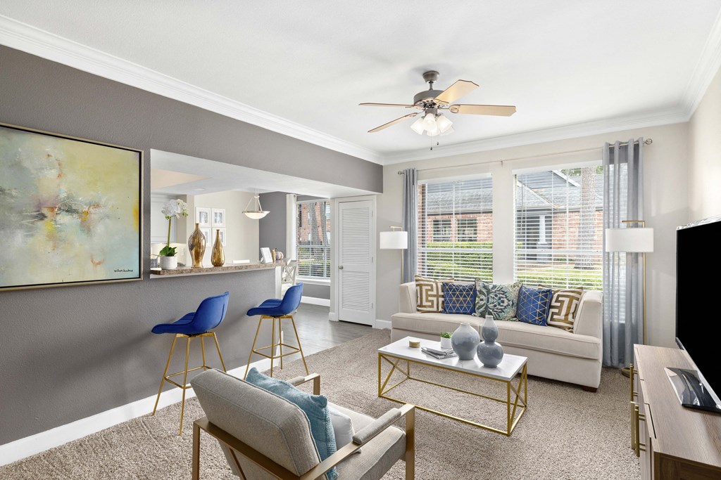 A living room with a grey couch, a coffee table, and a painting on the wall.