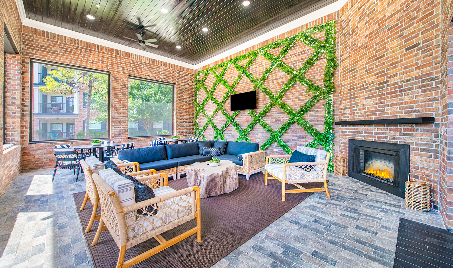 a living room with a brick wall with a fireplace
