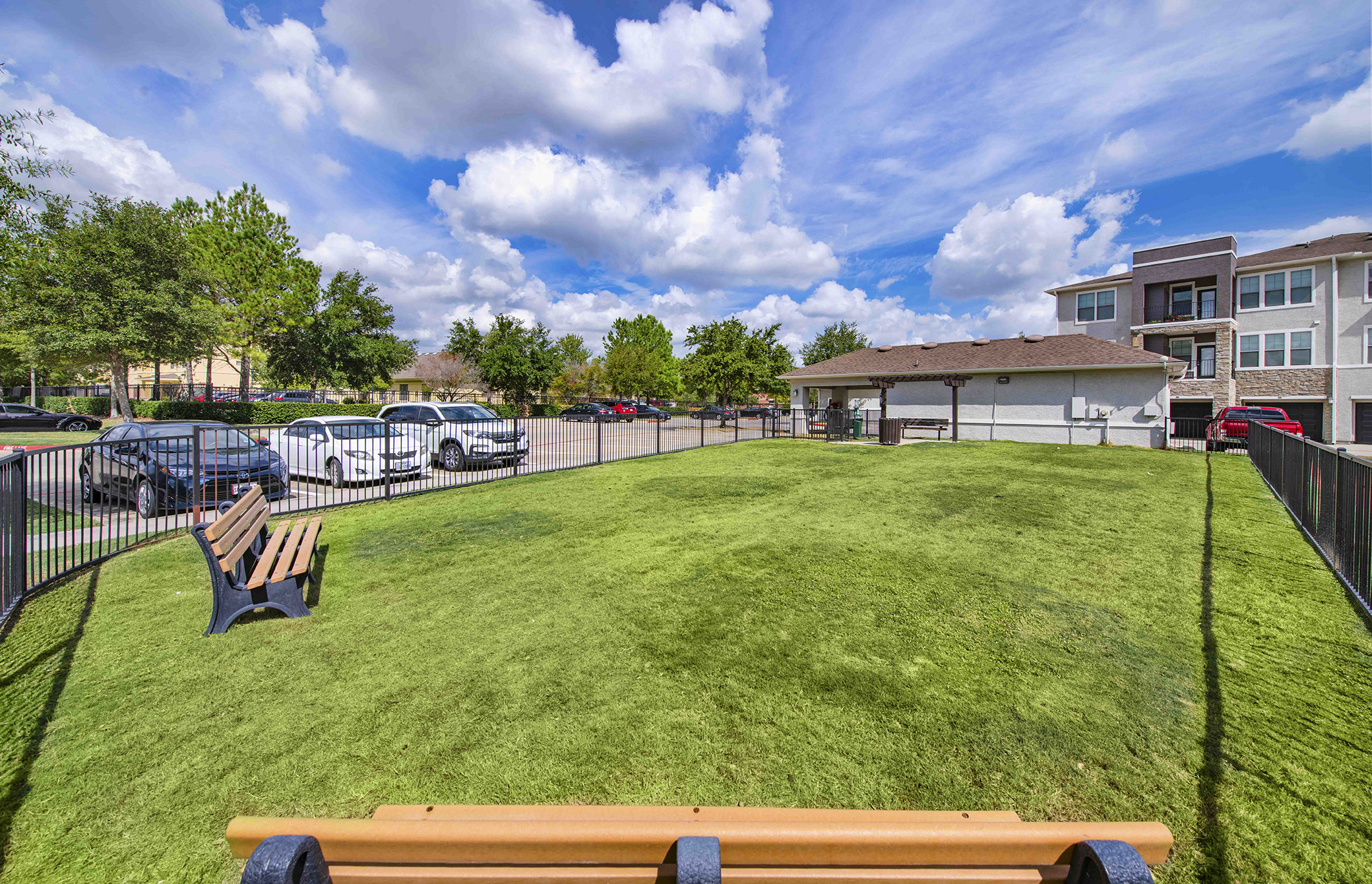 a large yard with a bench in front of a fence