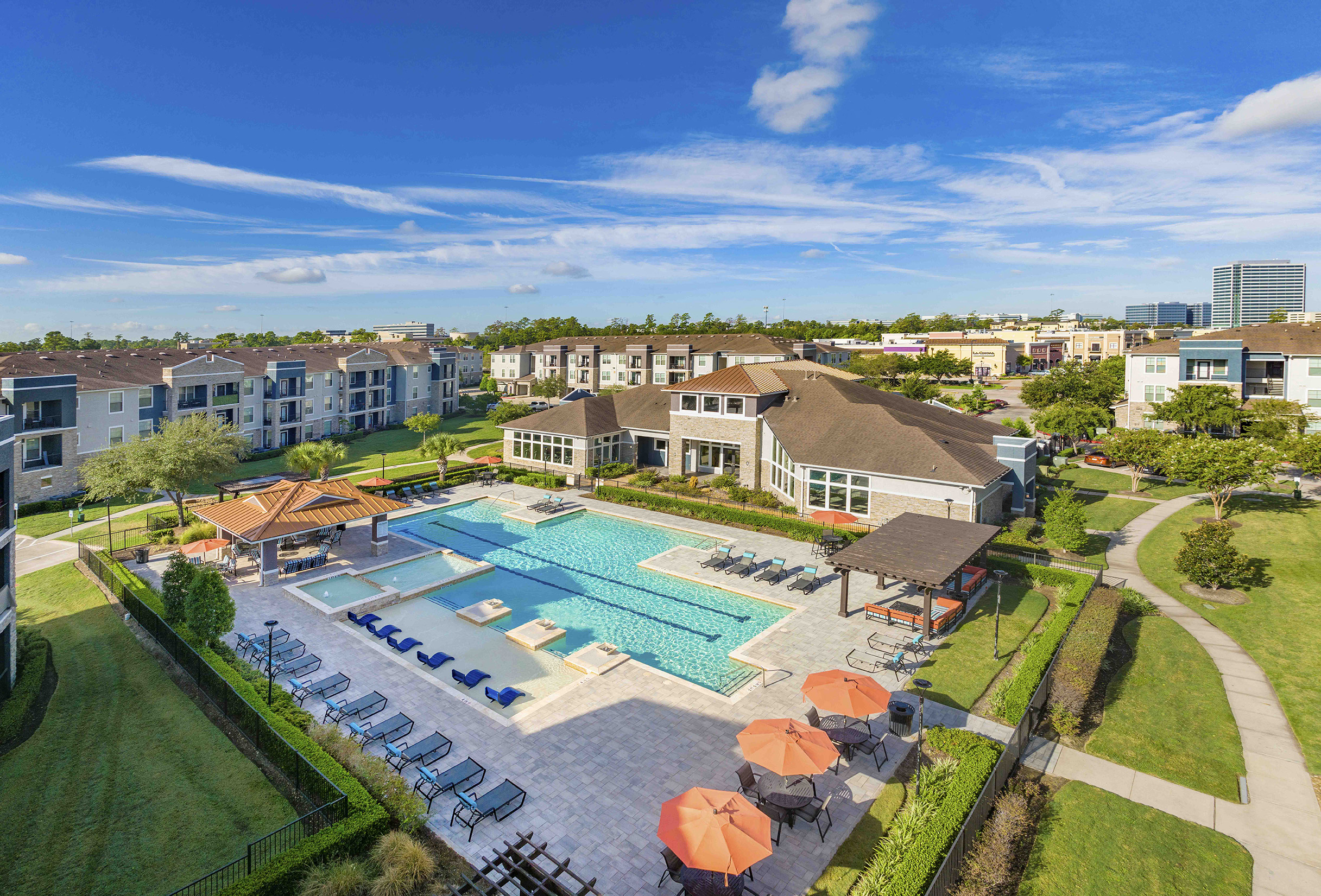 an aerial view of the resort style pool with lounge chairs and umbrellas