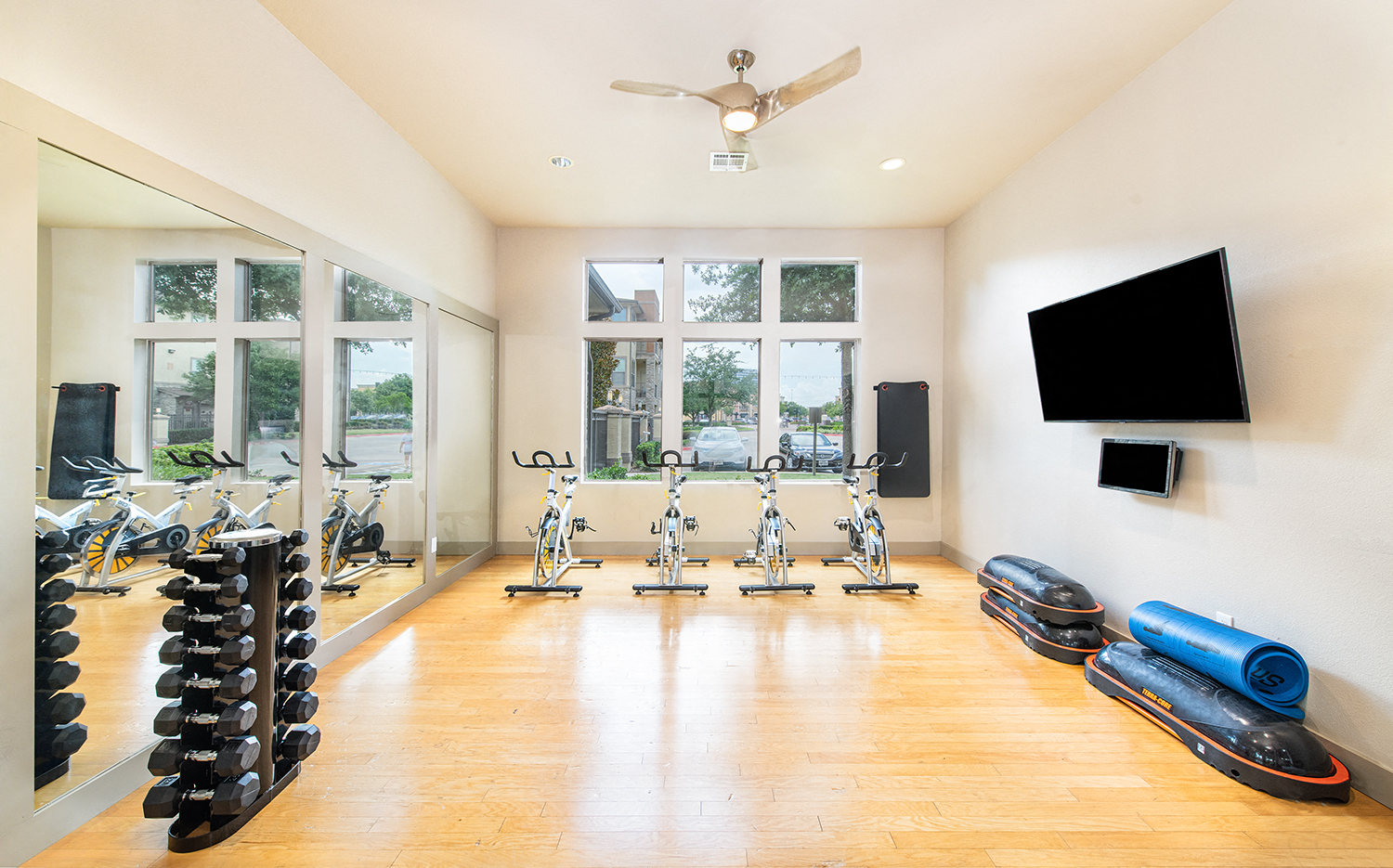 the home gym has plenty of exercise equipment and a large window