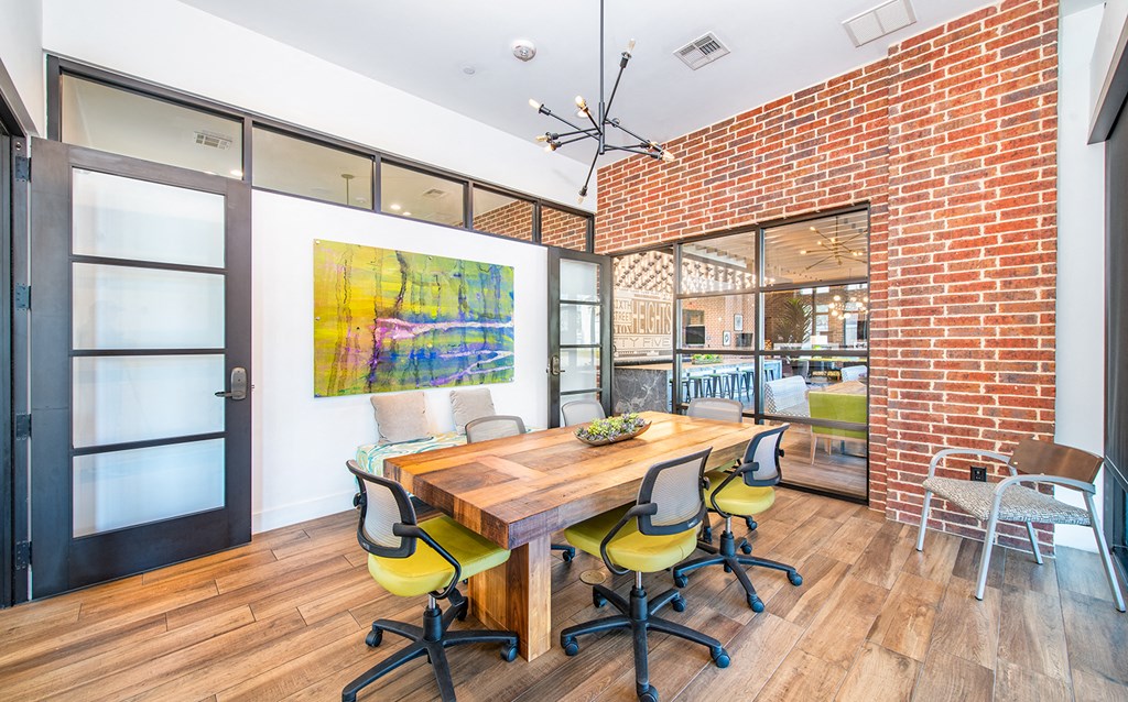 a conference room with a wooden table and chairs and a brick wall