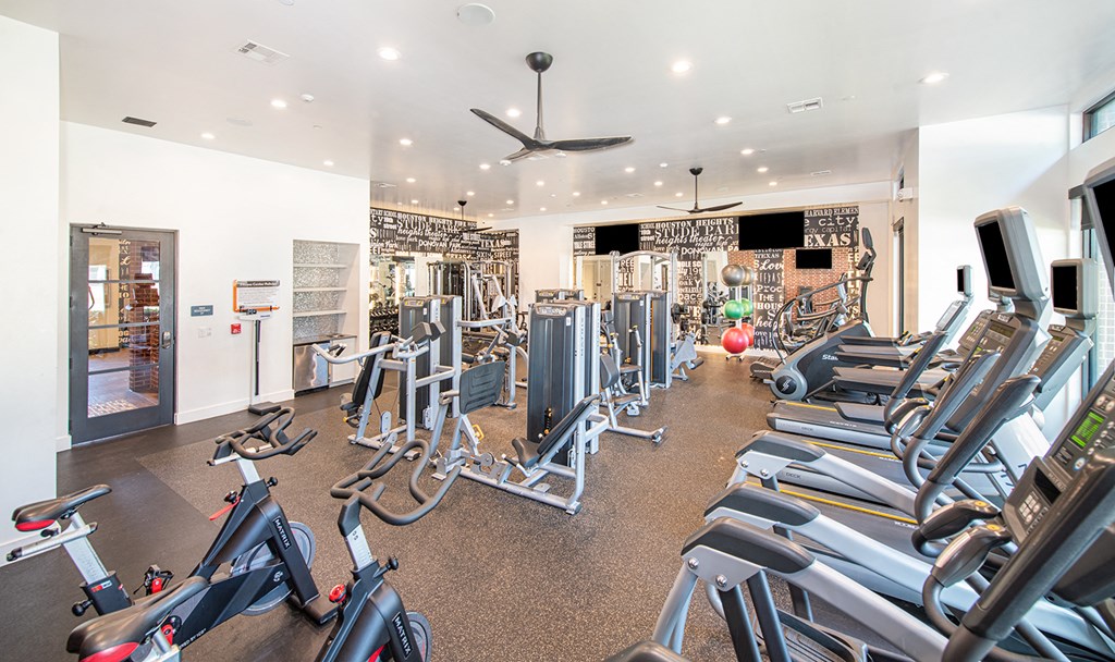 a gym filled with cardio equipment and exercise bikes