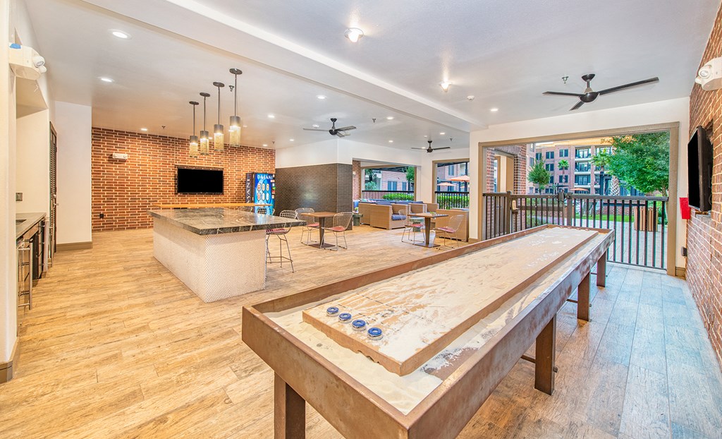 a large living room with a bar and a wooden table