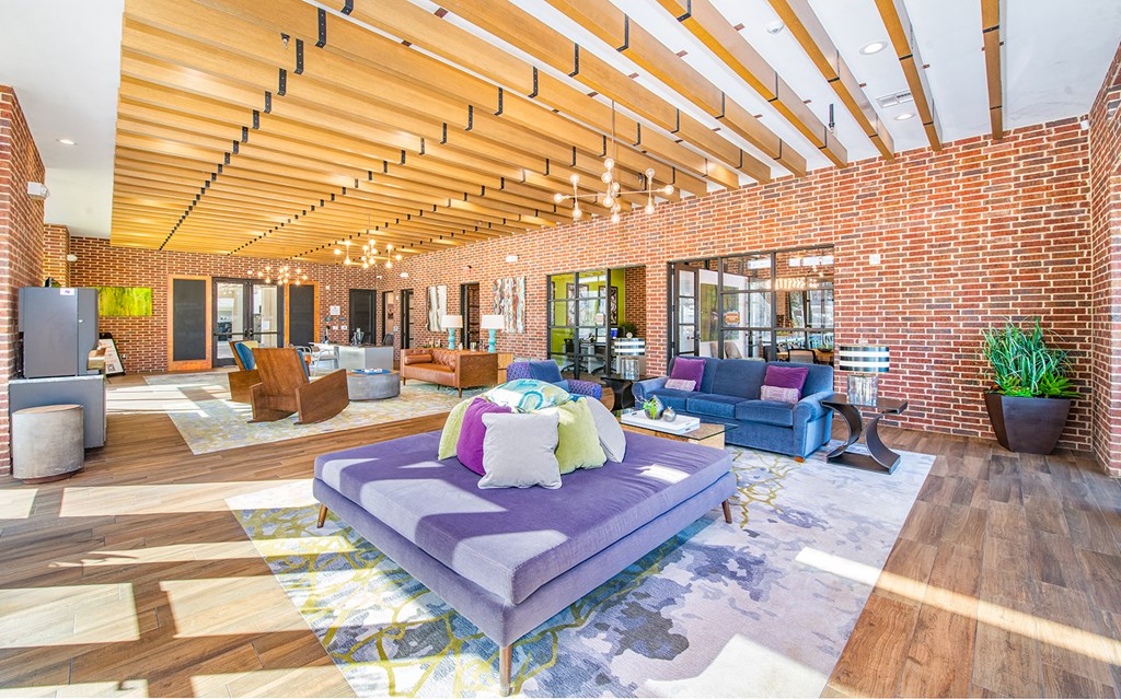 a living room with brick walls and a purple couch