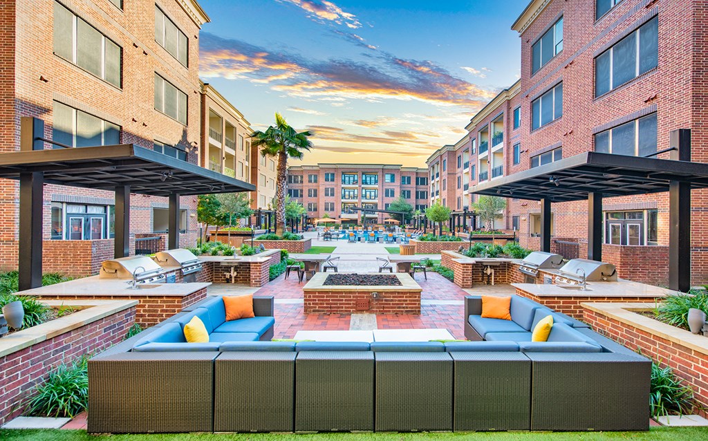 an outdoor lounge area of an apartment building with a fire pit