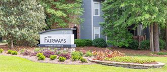 a sign for the fairways at prescott park in front of a blue house