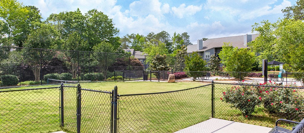 a fenced in yard with a playground and trees