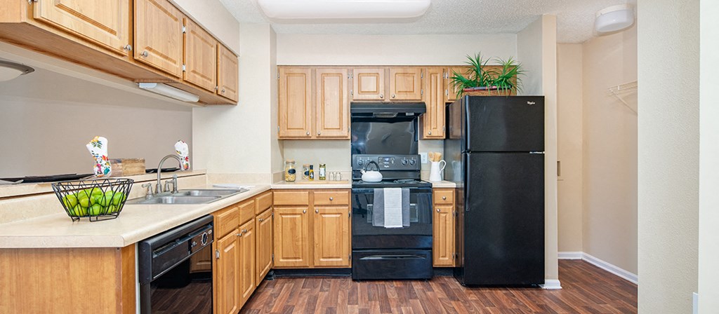a kitchen with black appliances and wooden cabinets