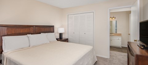 a bedroom with a bed and a door to a bathroom