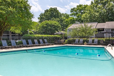 a swimming pool with blue chairs and a resort style pool