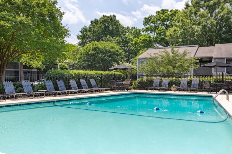 a swimming pool with blue chairs and a resort style pool