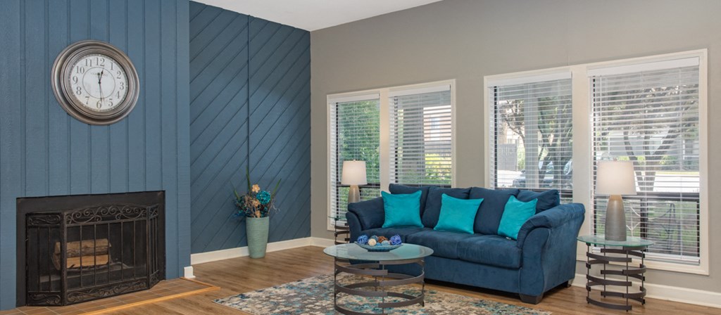 a living room with a blue couch and a fireplace