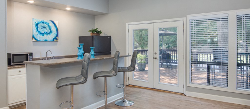 a kitchen with a bar and sliding glass doors to a patio