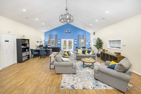 A living room with a grey couch, a coffee table, and a chandelier.
