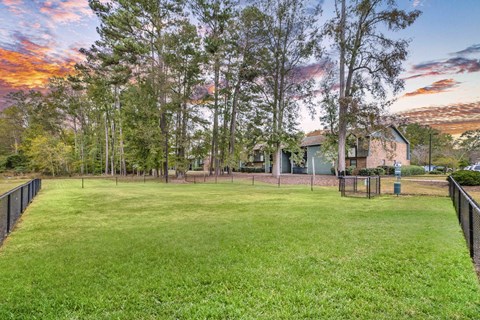 A backyard with a fence and a house in the background.