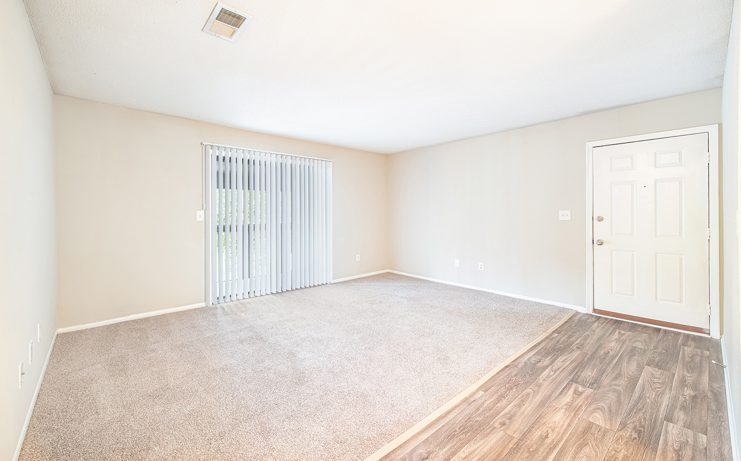 an empty living room with a door to a closet