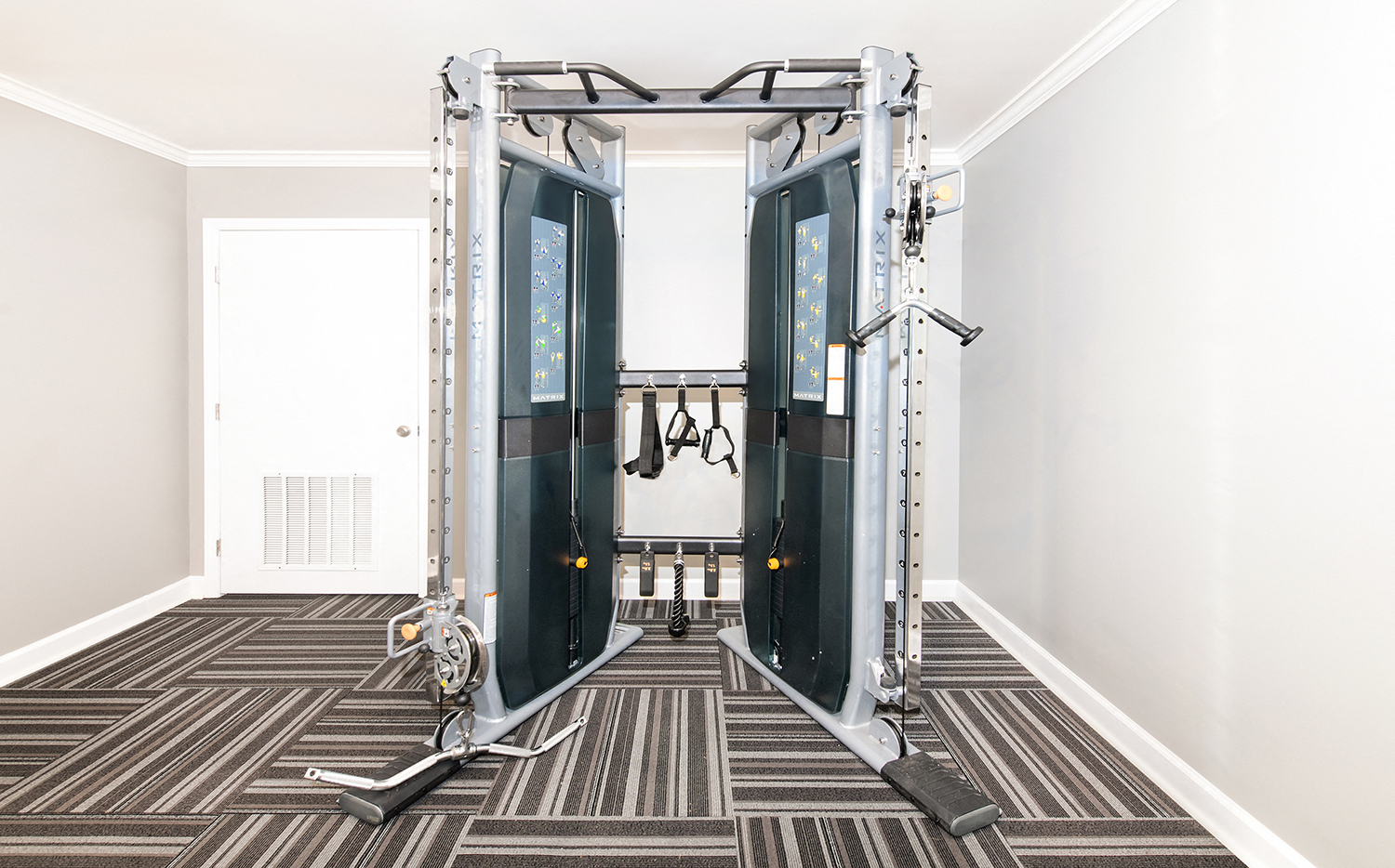 a fitness room with a pair of exercise machines in it