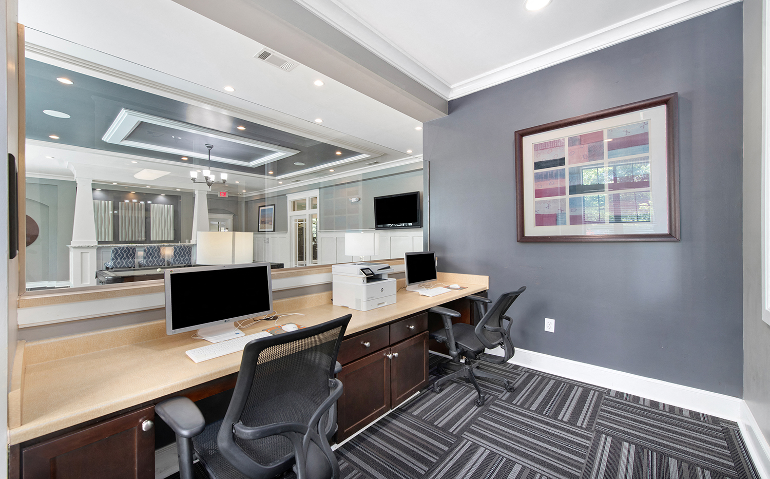 a modern office with two desks and two computer monitors