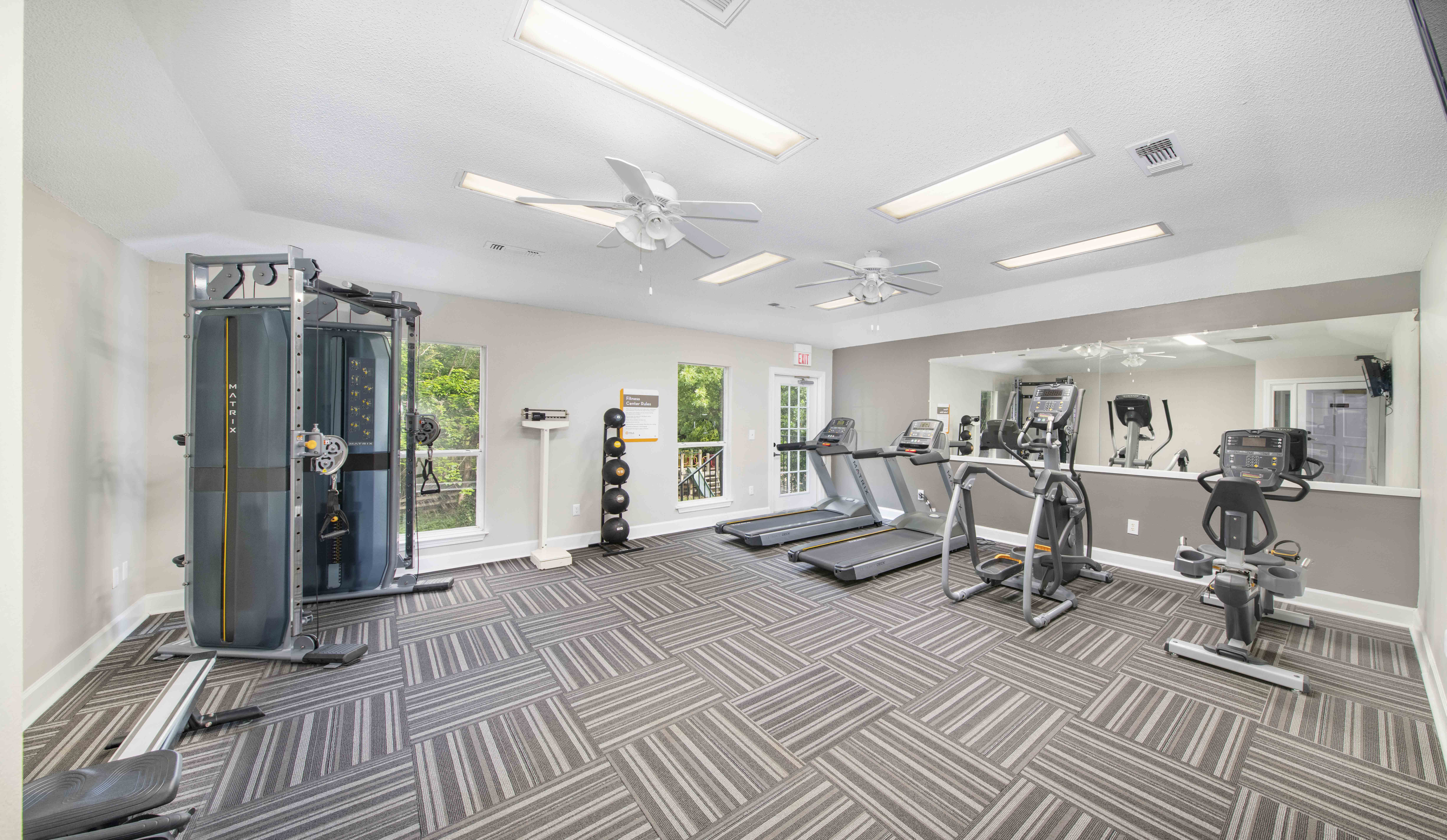 a gym with cardio machines and sprinklers on the floor