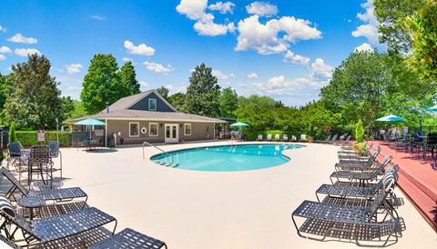 our resort style pool is surrounded by lounge chairs and umbrellas