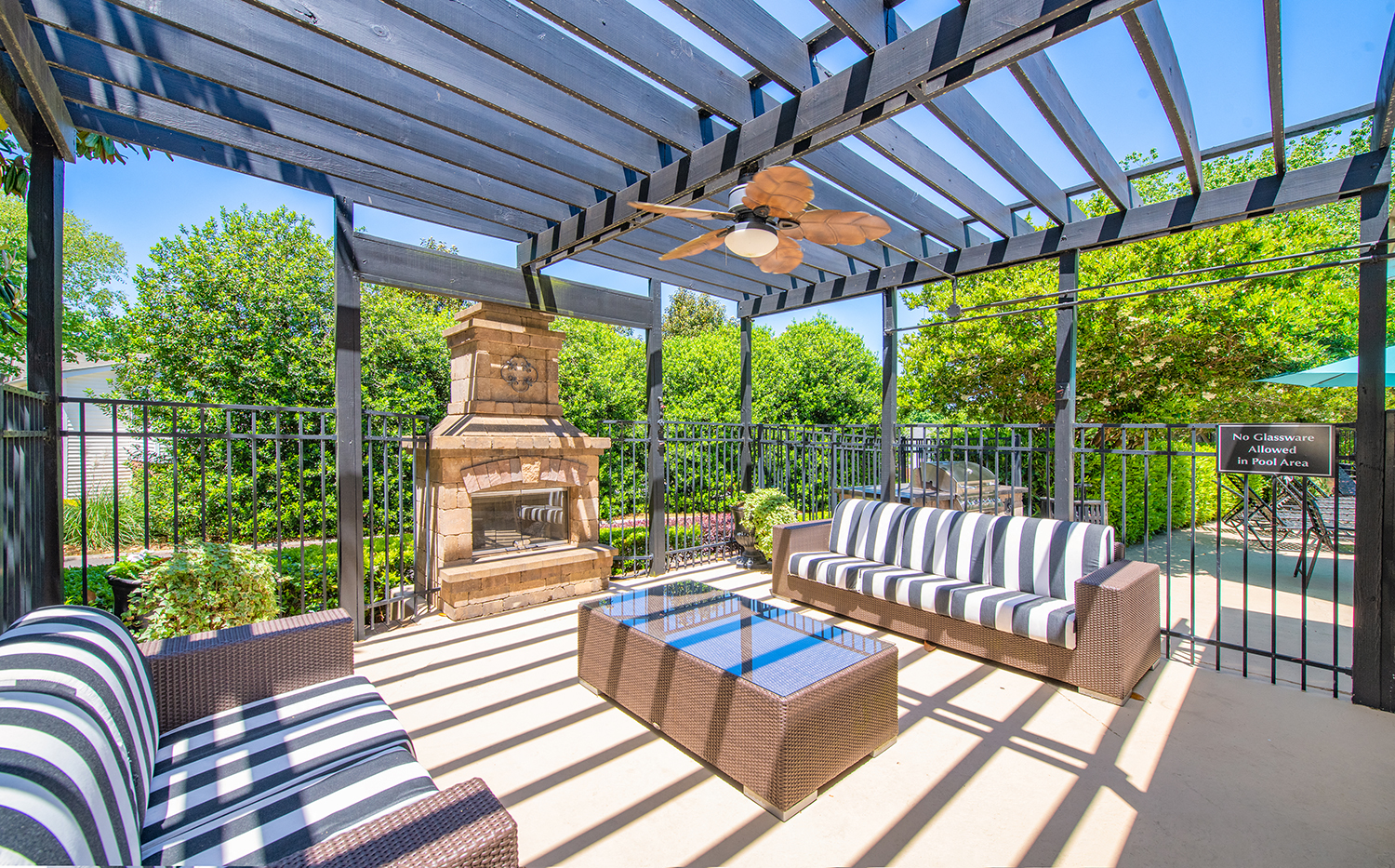 the patio has a fireplace and furniture under a pergola