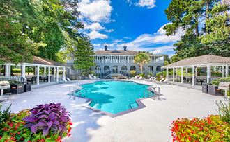 a large swimming pool with a mansion in the background