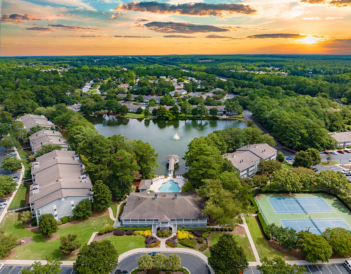 an aerial view of a community with a lake and buildings