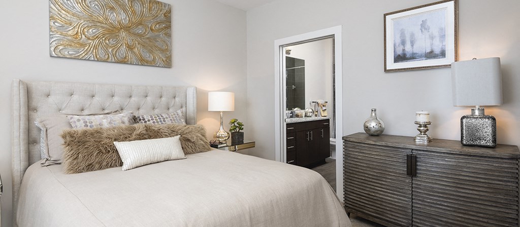 a bedroom with a bed and a dresser and a mirror