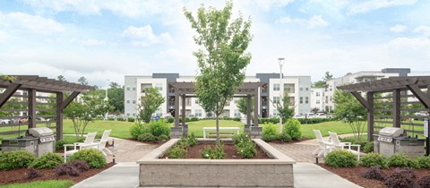a rendering of a park with benches and buildings in the background
