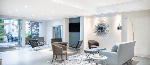 a living room with a couch and chairs and a tv