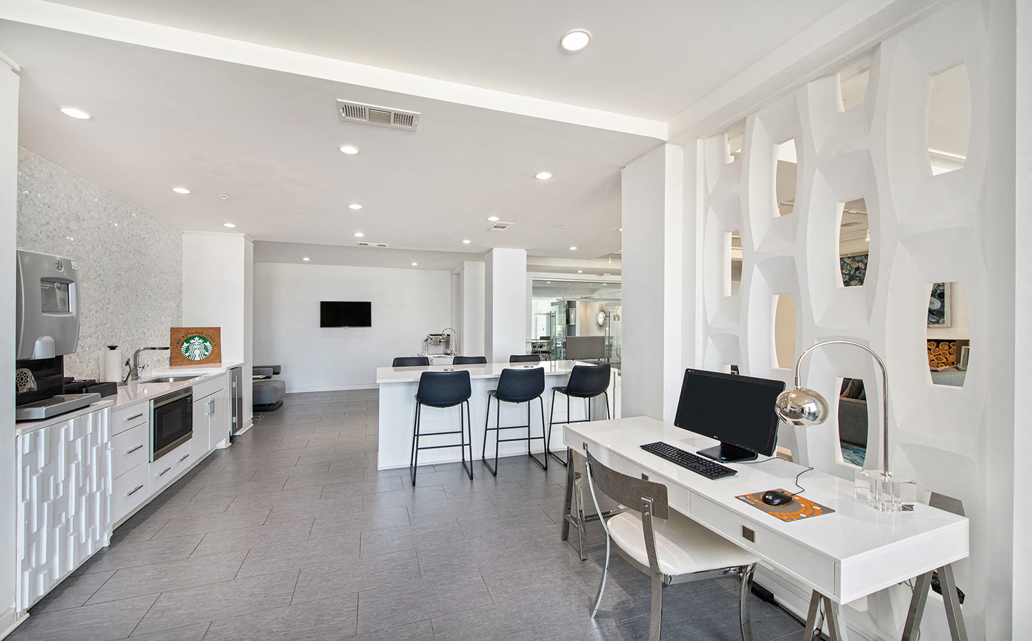 a white office with a desk and chairs and a computer
