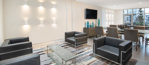 a living room with chairs and a table and a television