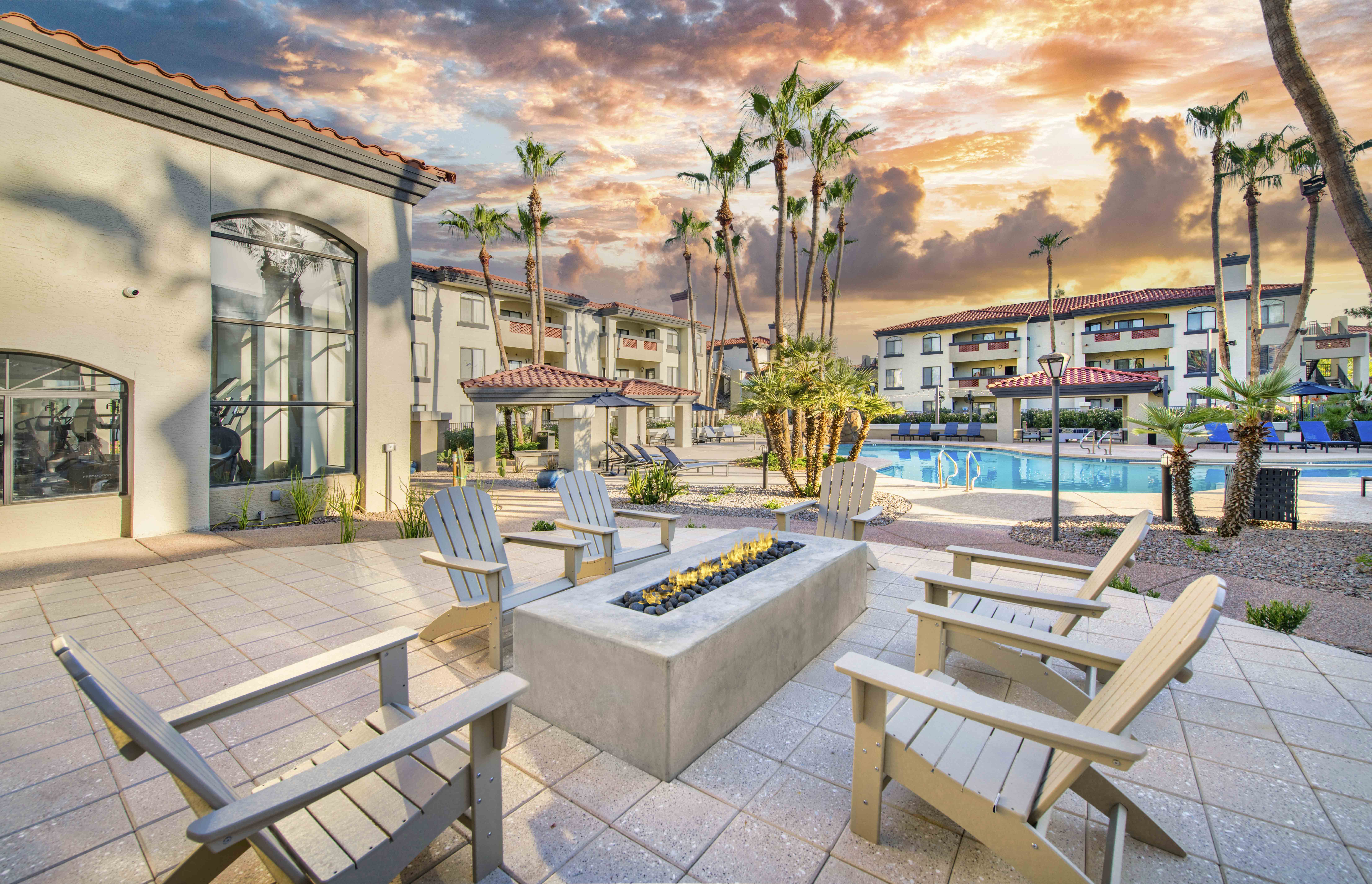 a patio with tables and chairs and a fire pit