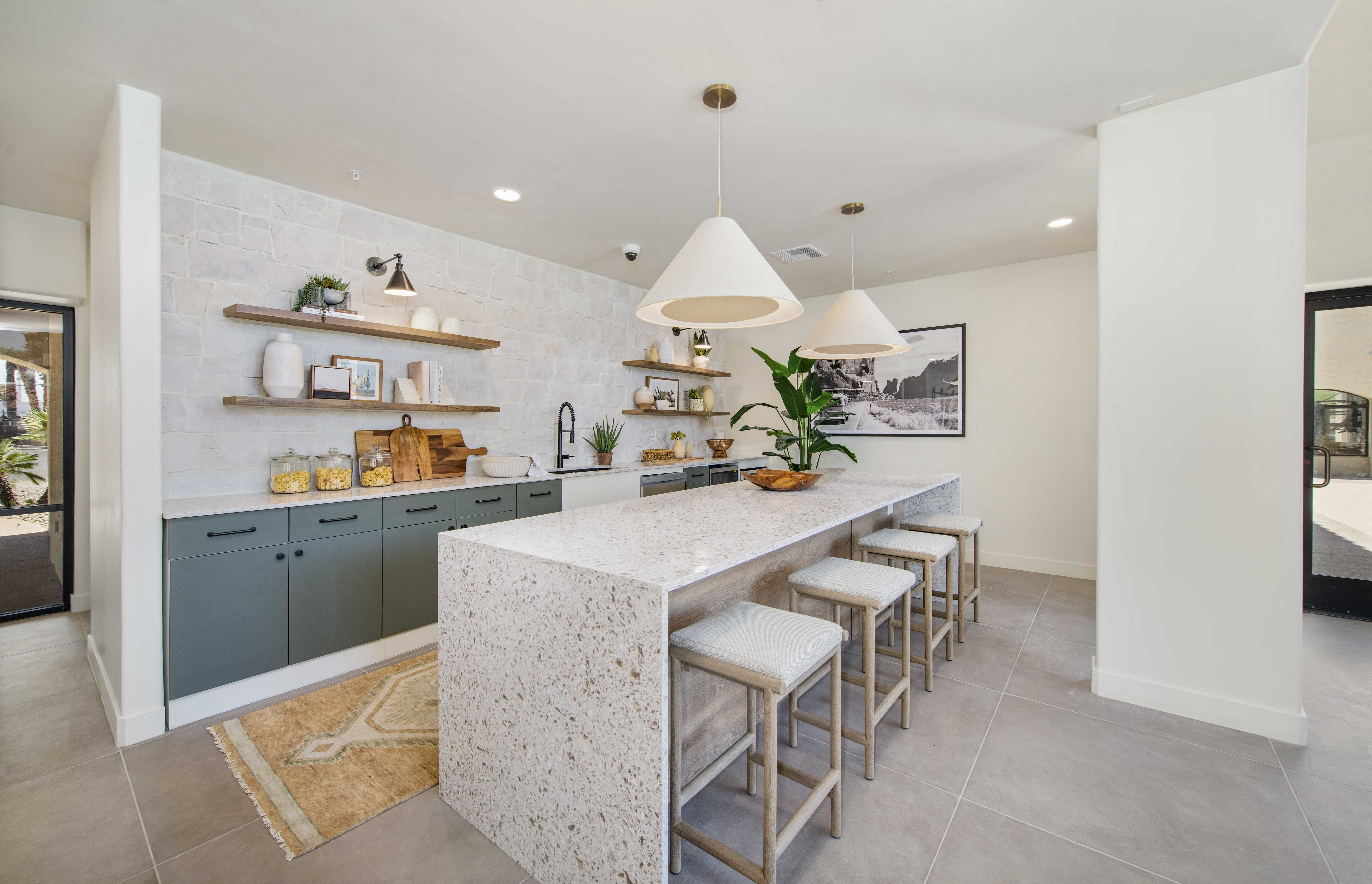 a kitchen with a long counter and stools in a house