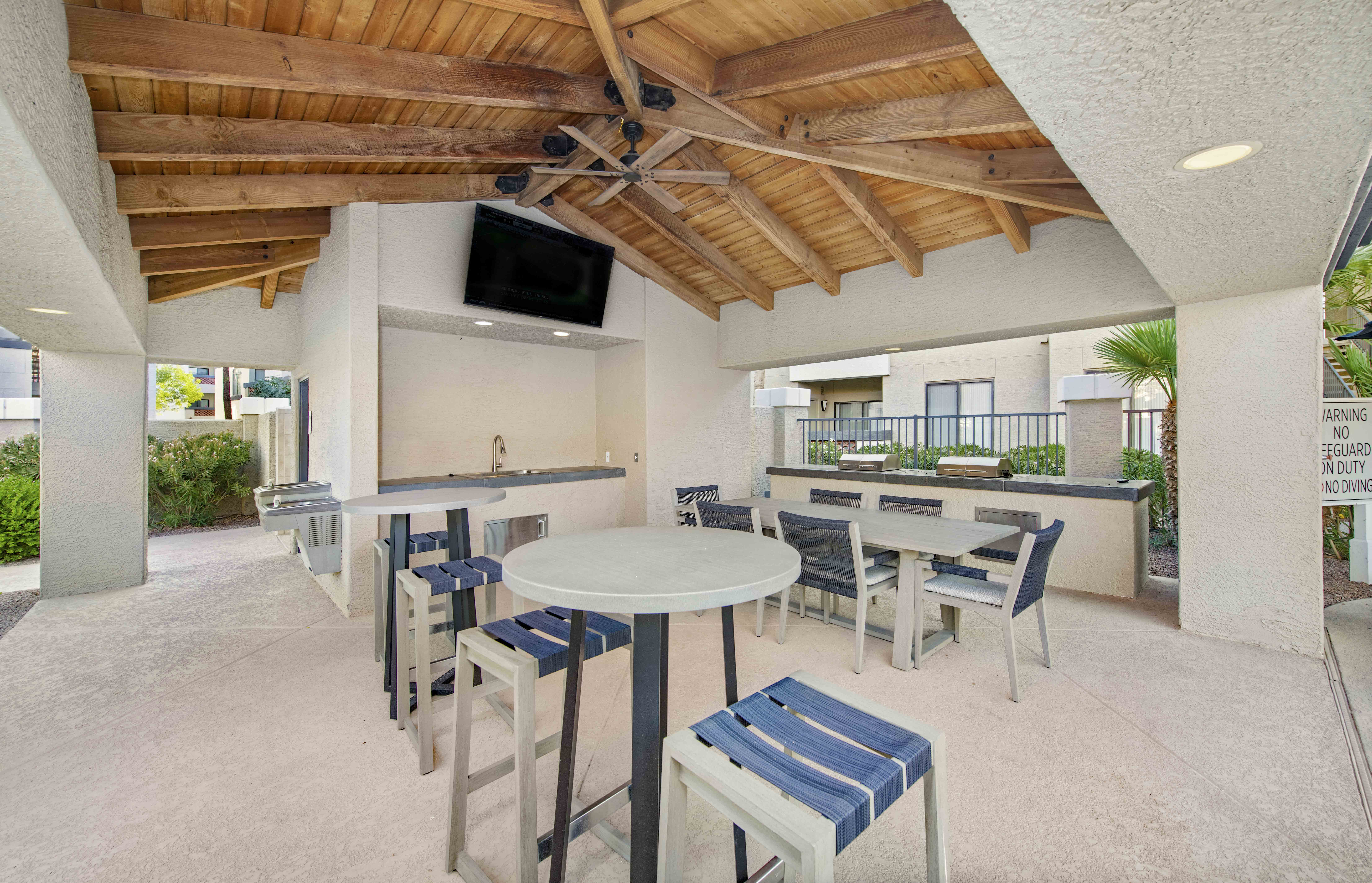 a patio with tables and chairs and a bar