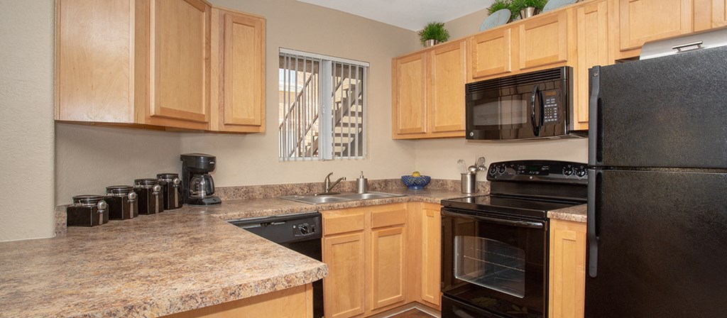 a kitchen with black appliances and granite counter tops
