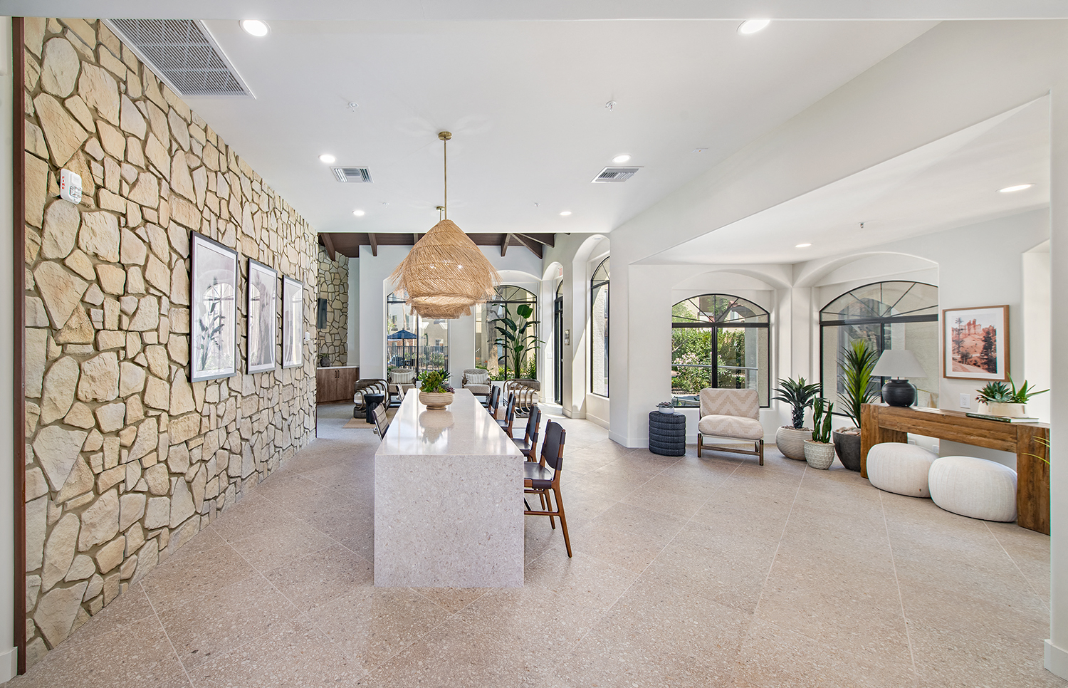 a large living room with a long table and a stone wall