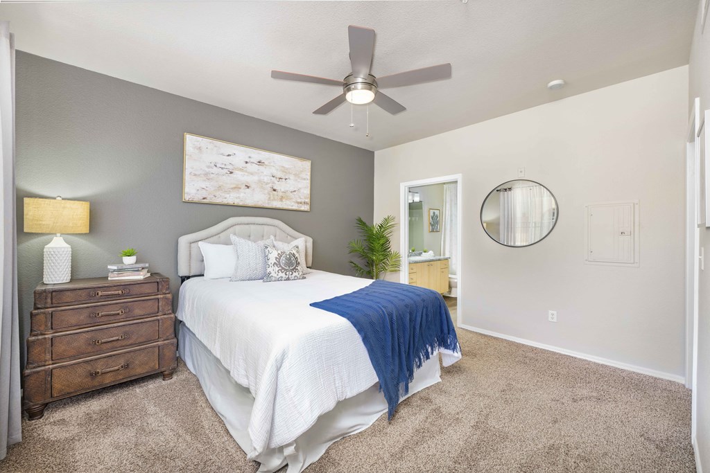 a bedroom with a bed and a ceiling fan