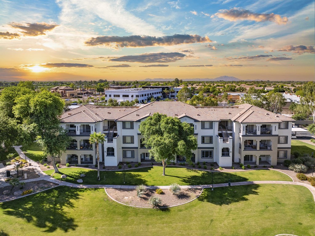 an aerial view of an apartment building with green grass and trees